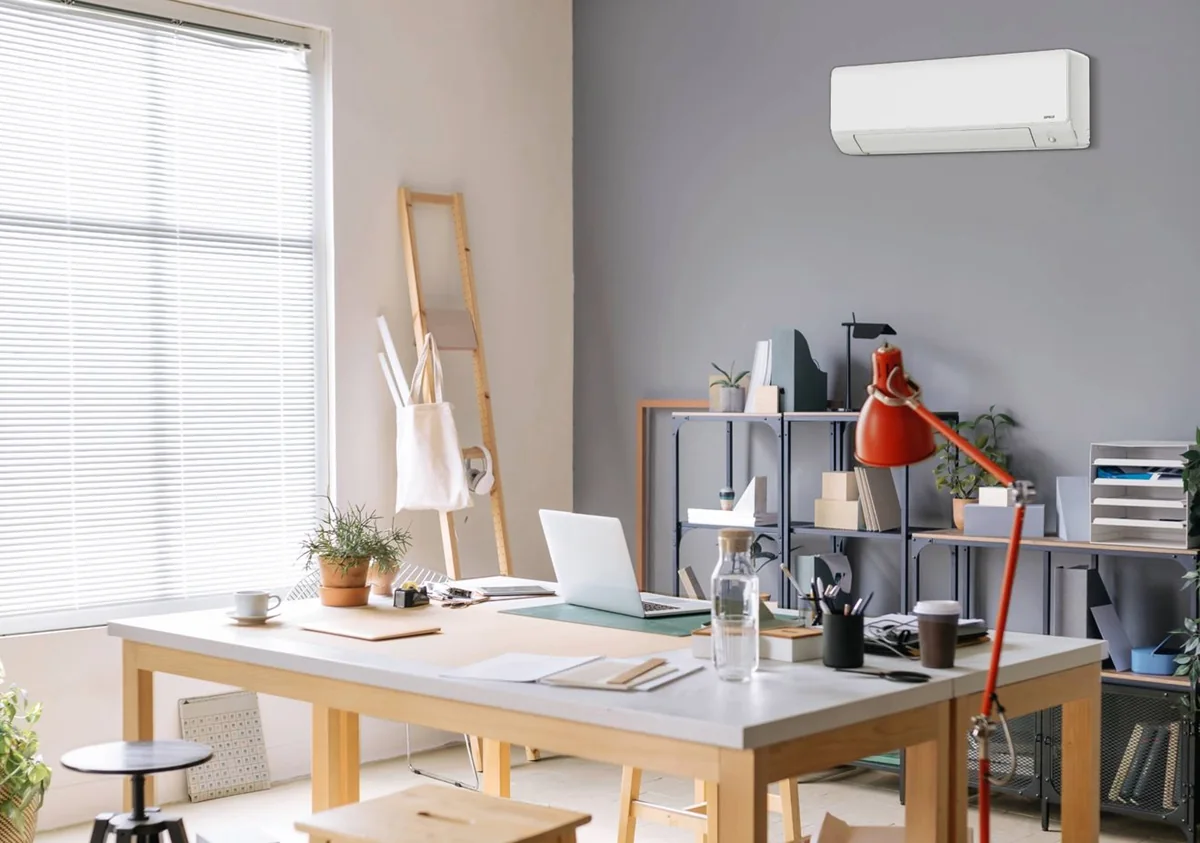Salon lumineux avec une thermopompe murale Capella au-dessus de la fenêtre